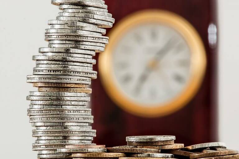 stacking coins in front of clock