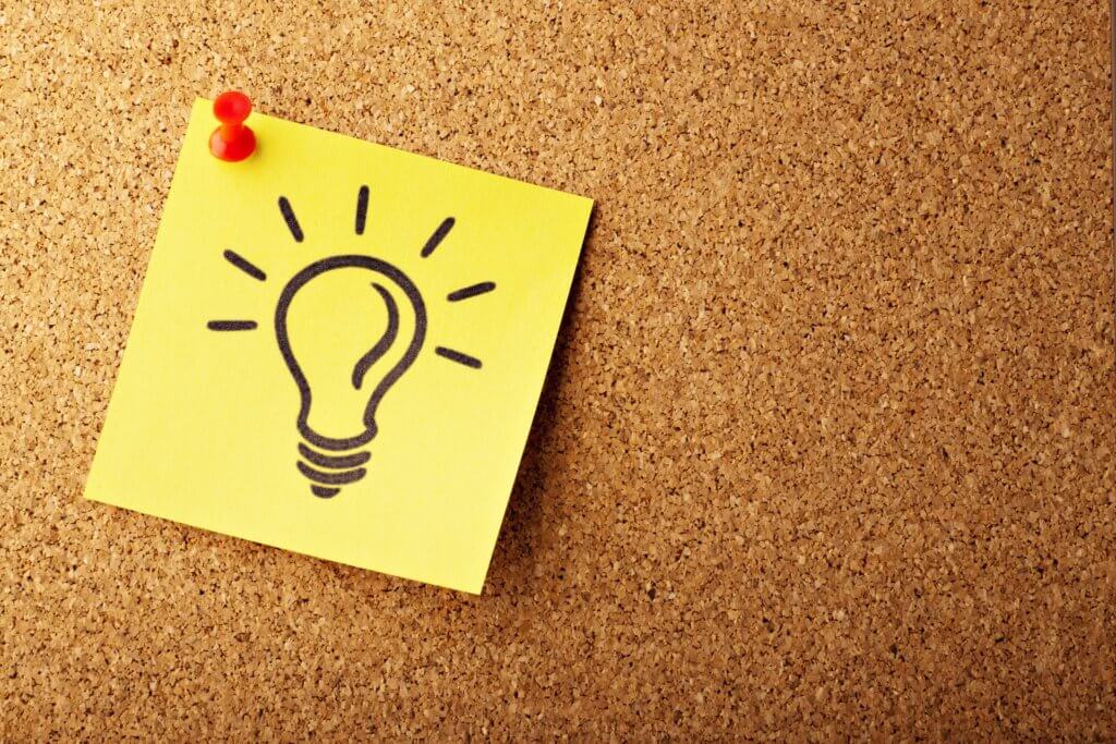 drawing of a lightbulb on a post-it note pinned to a corkboard