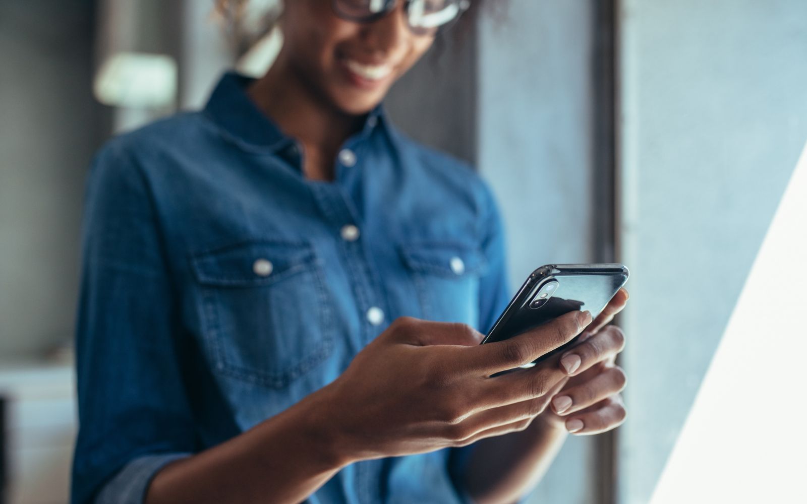 Woman holding a phone and smiling. 