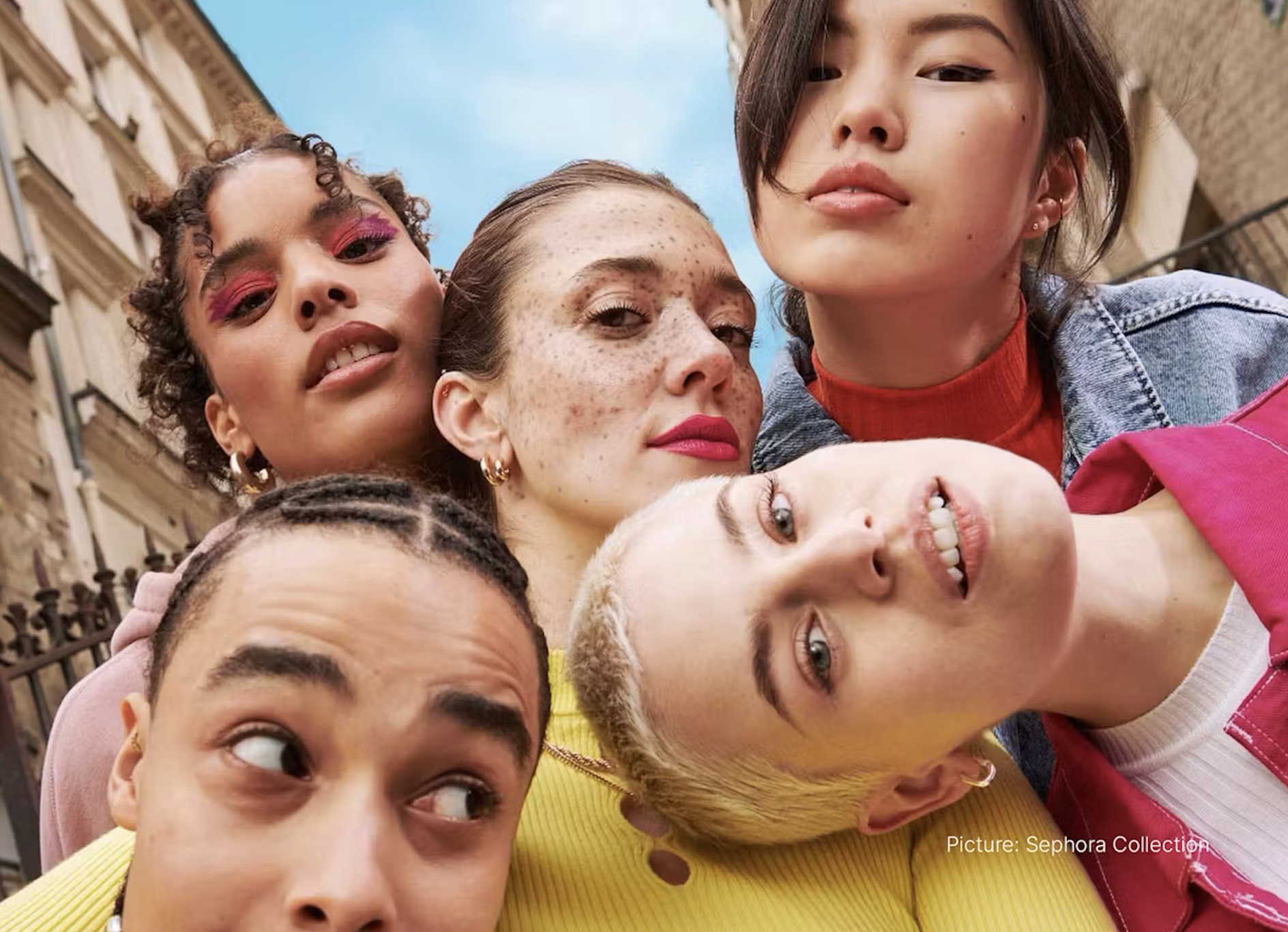 Five women looking into the camera smiling. 
