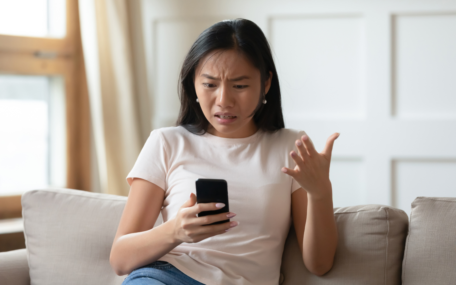 Person looking at their phone in frustration and confusion.