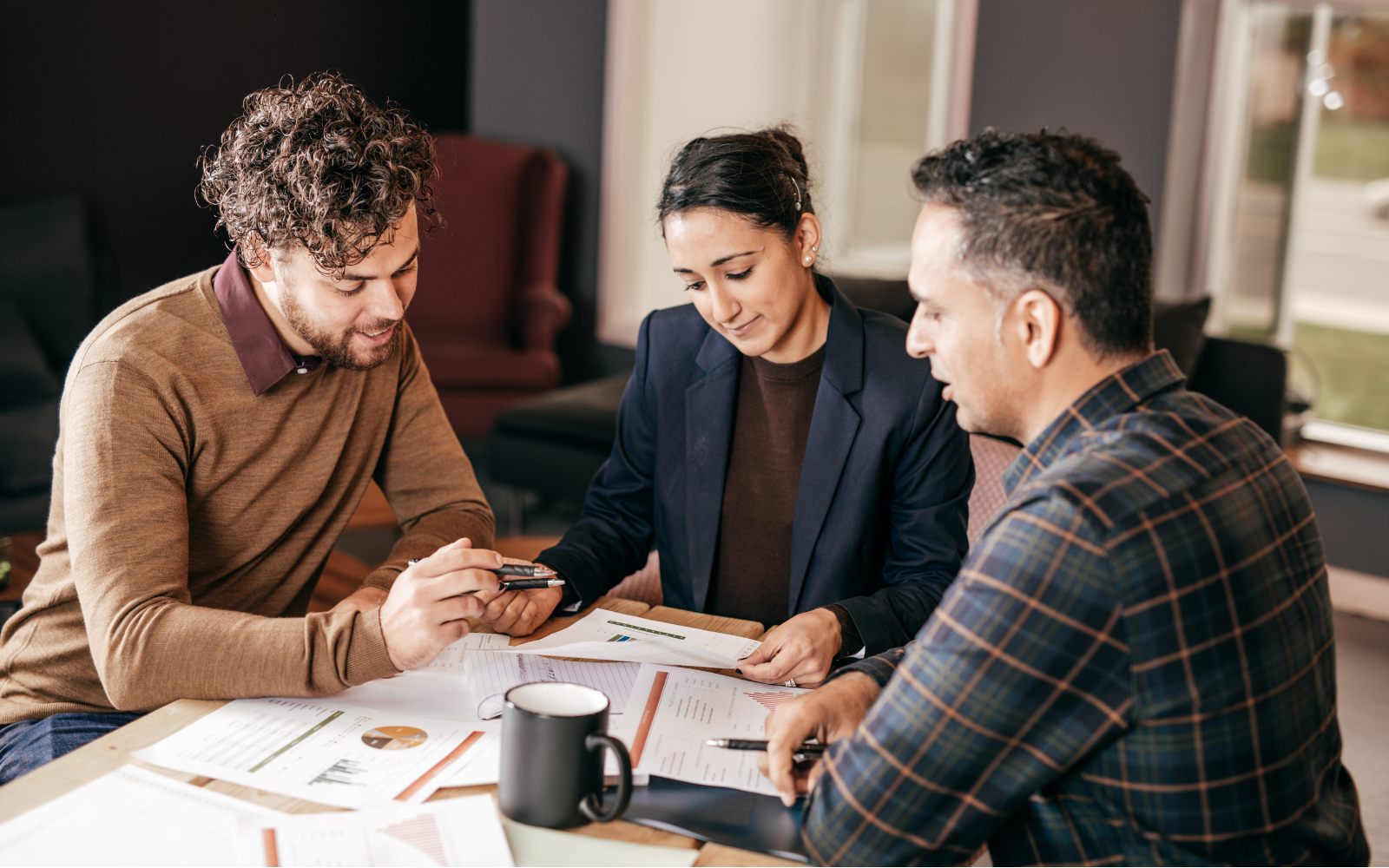 People discussing plans around a table