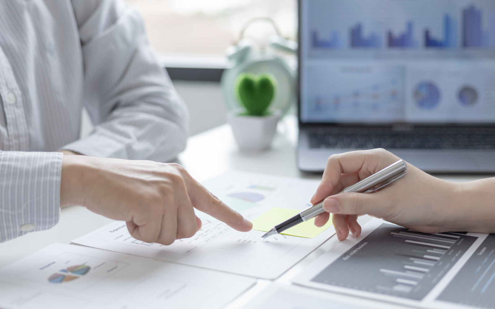 Business reviewing charts showing customer visits and reward redemptions. 