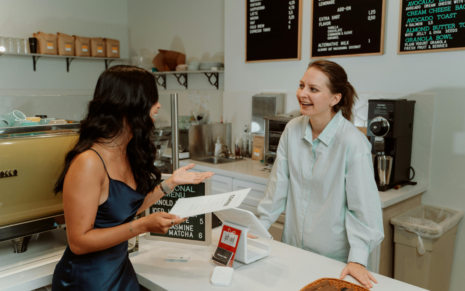 Café staff answering customers questions confidently at checkout
