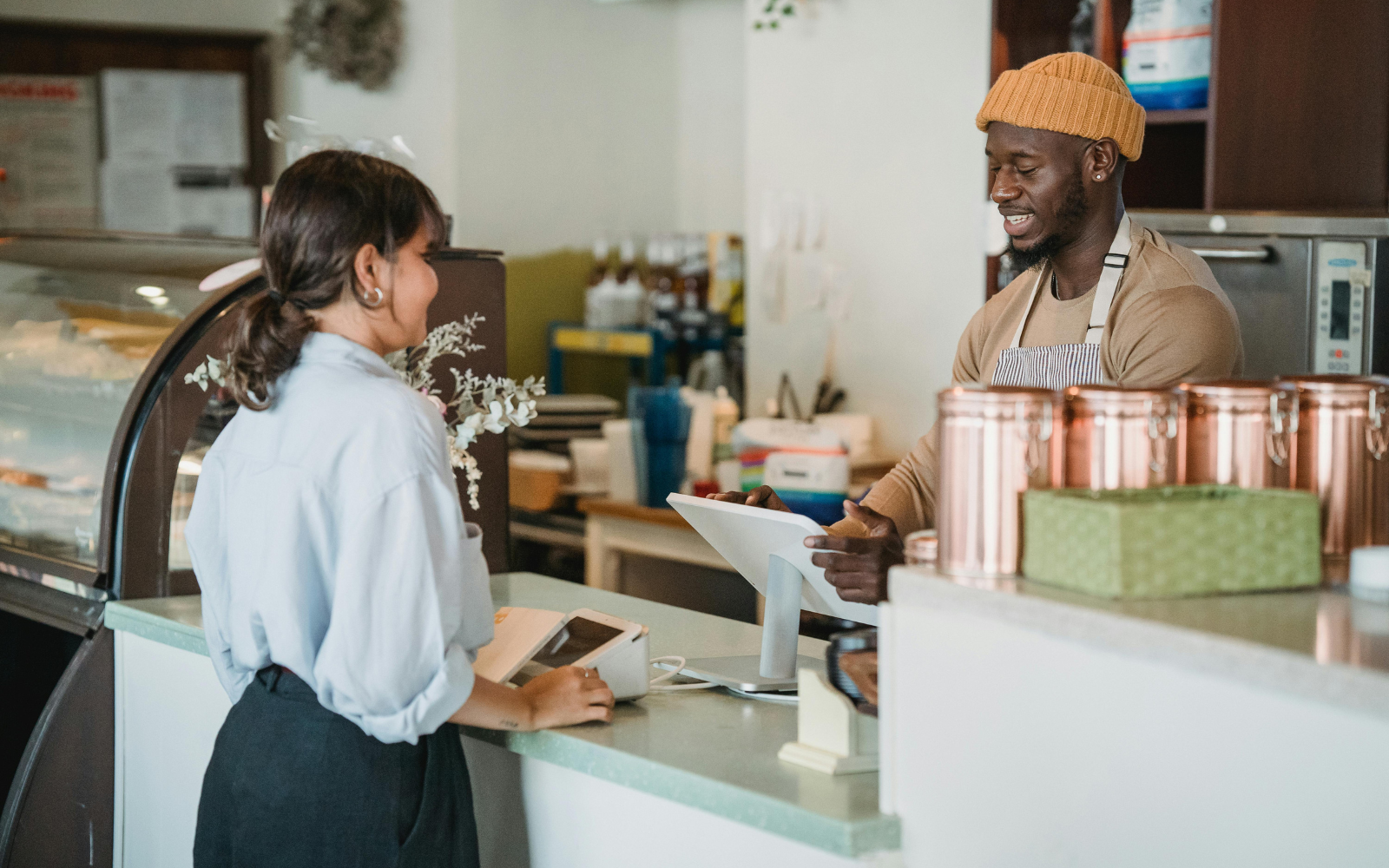 Customer scanning digital loyalty app at a New Zealand cafe counter.